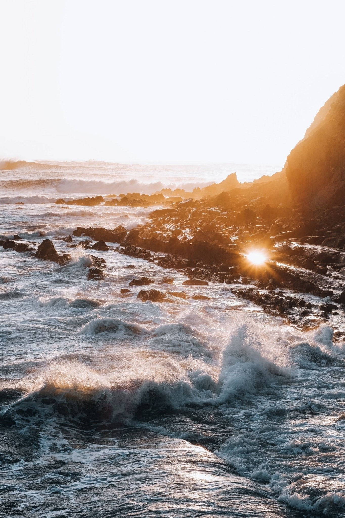 Costa rocosa junto al mar al atardecer, evocando bienestar y los beneficios del mar para la salud