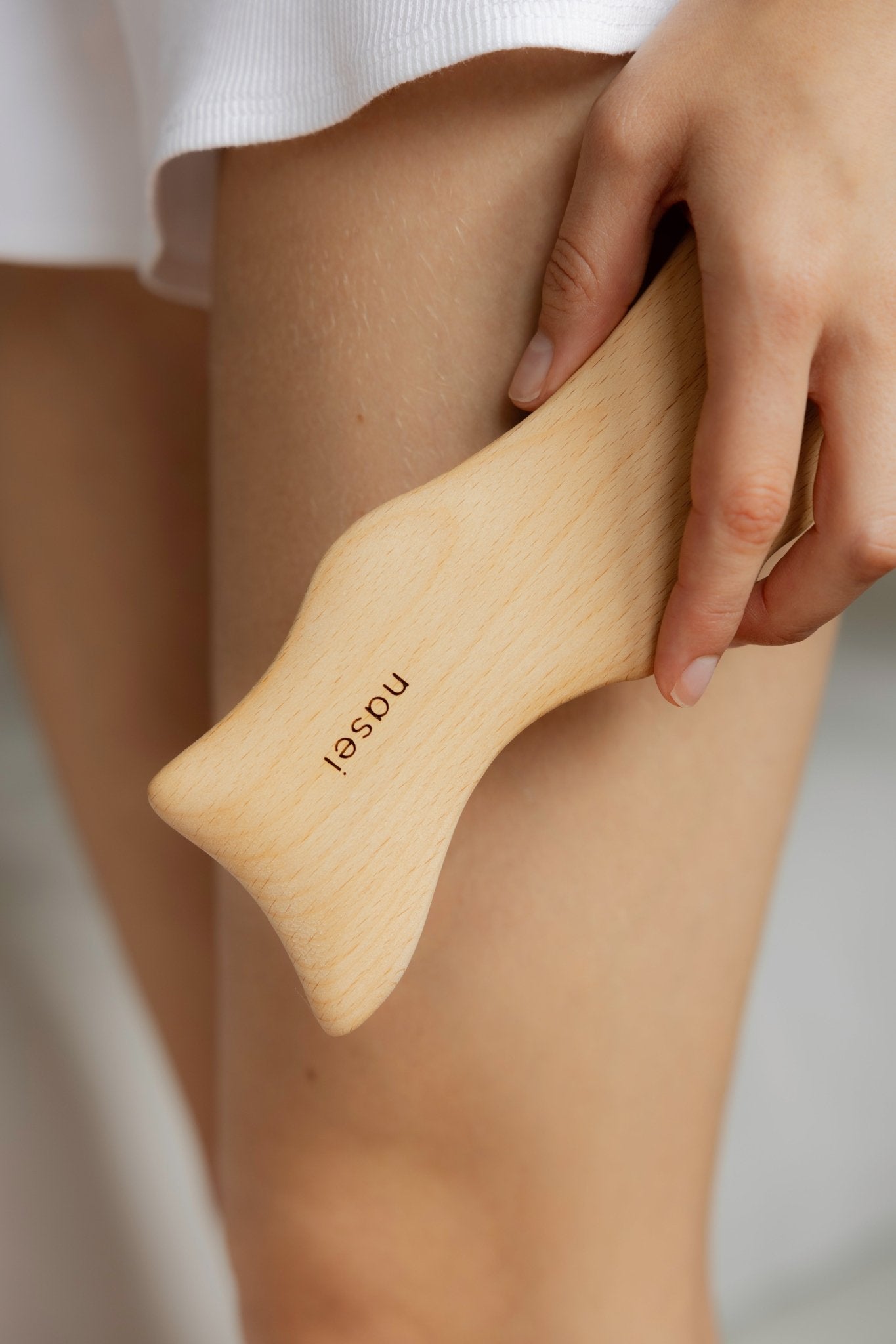 Masaje corporal de maderoterapia en la pierna con Gua sha de madera