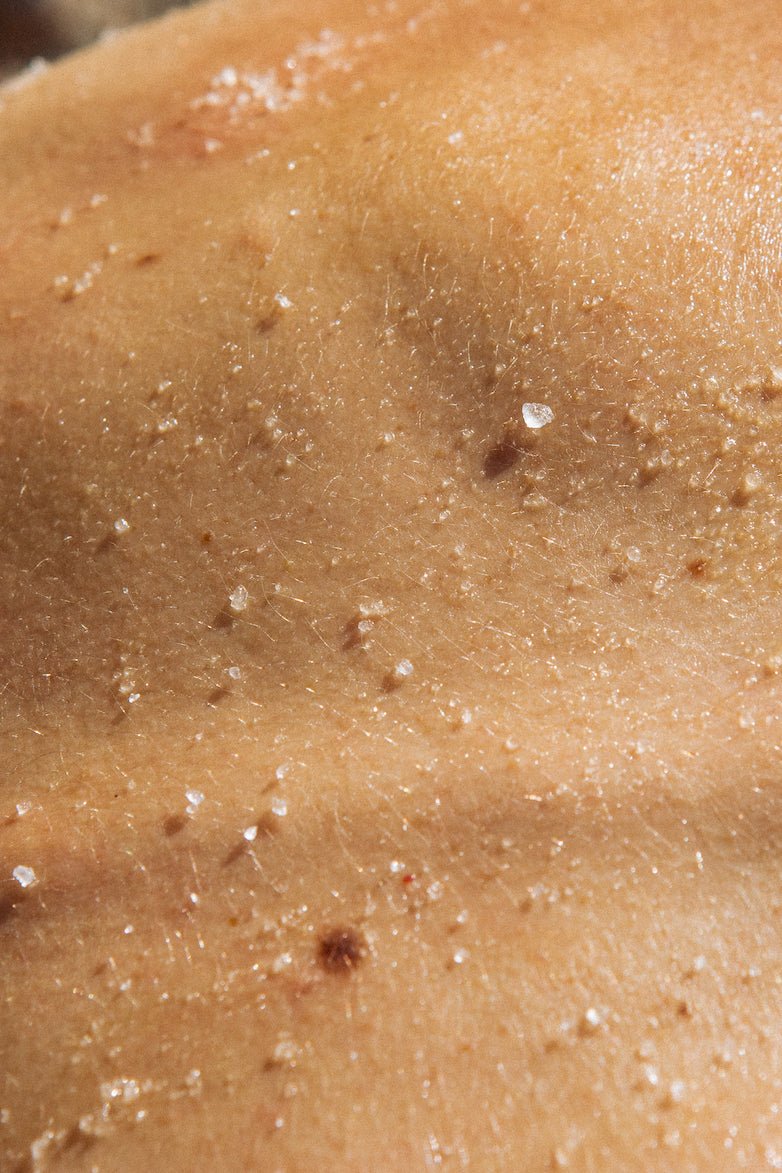 Exfoliación corporal sobre piel bronceada con partículas exfoliantes